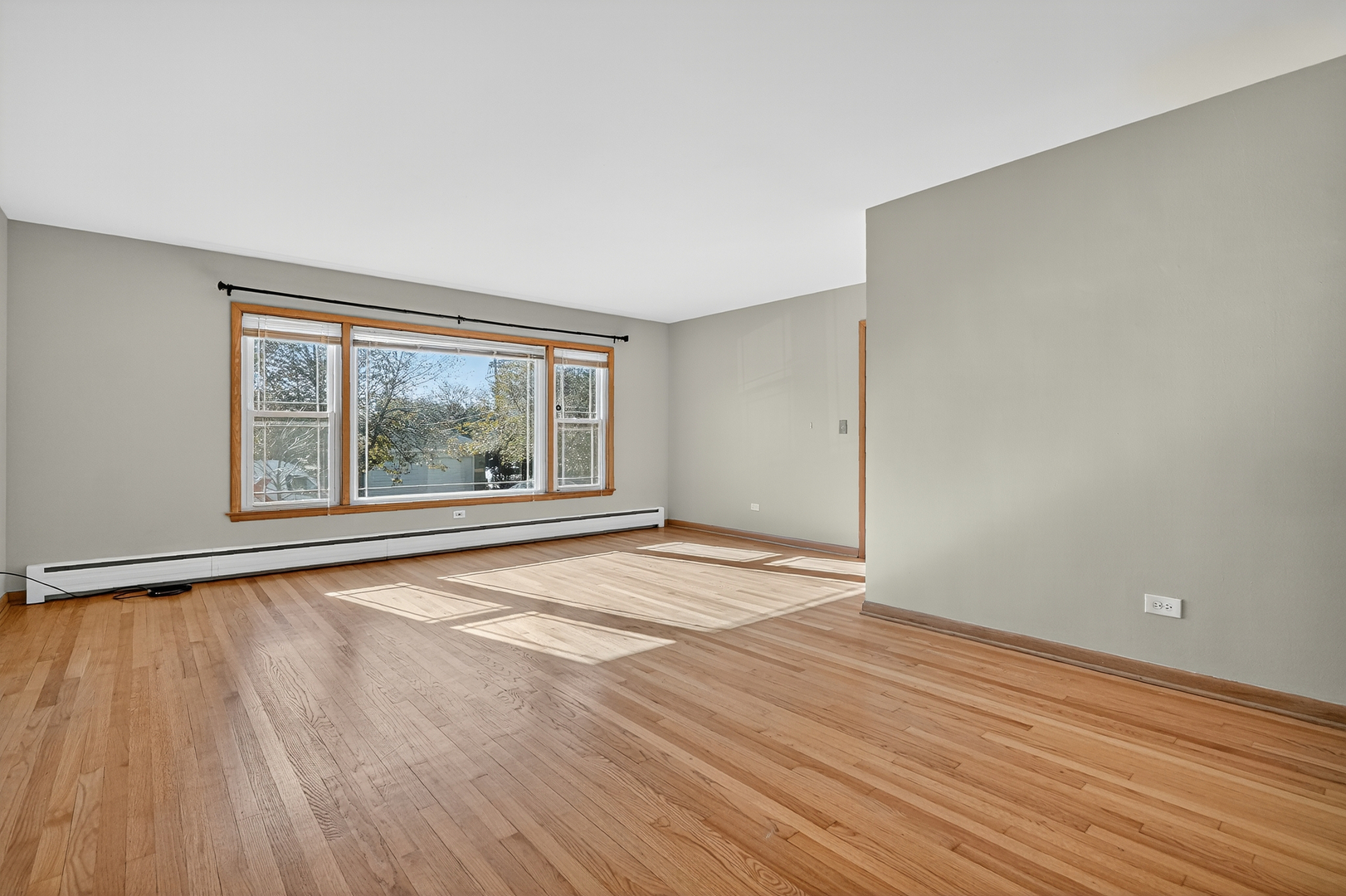 6408 West Raven Street, Unit 1 Chicago, IL 60631 - Photo 4 of 24 wooden floor in an empty room with a window