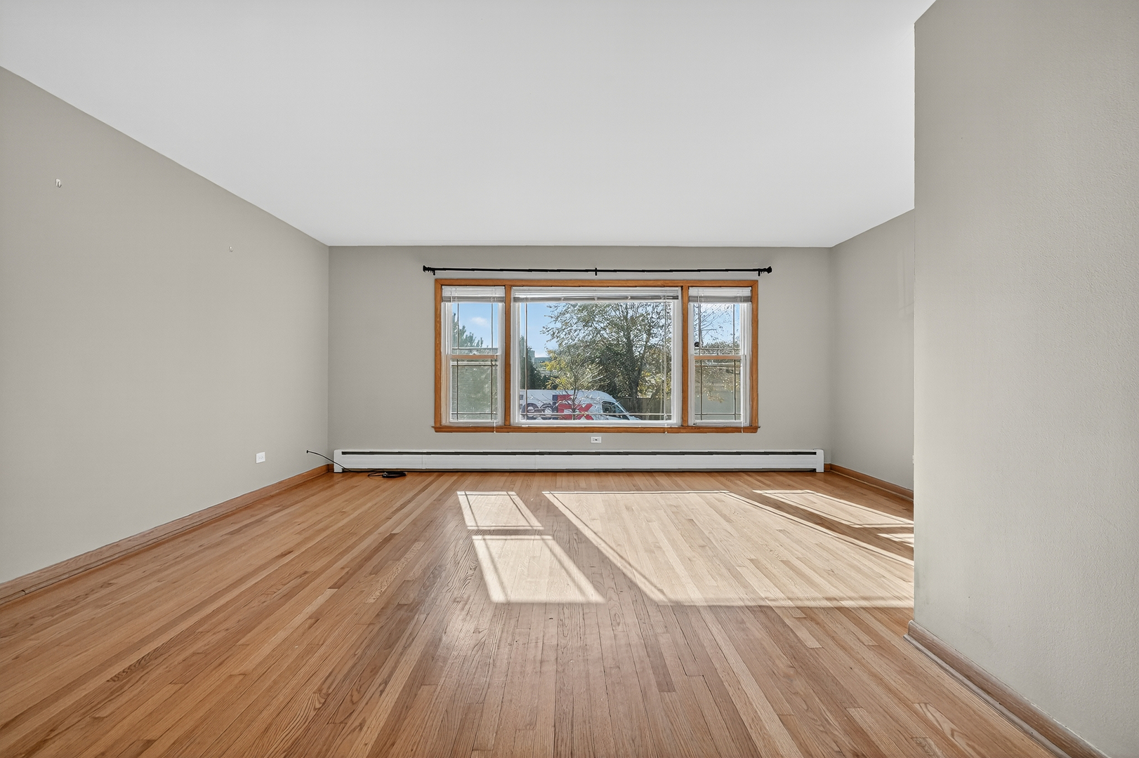 6408 West Raven Street, Unit 1 Chicago, IL 60631 - Photo 5 of 24 wooden floor in an empty room with a window