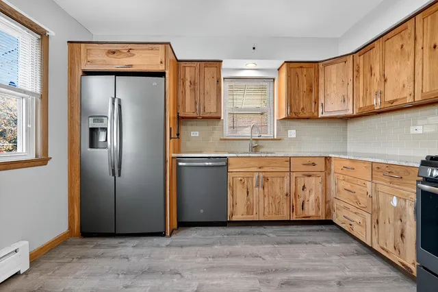 a kitchen with stainless steel appliances granite countertop a stove a sink and a microwave