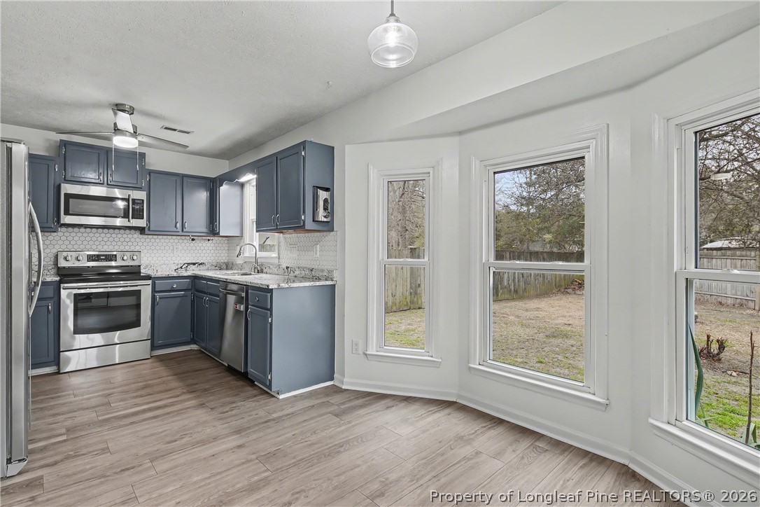 5073 Linton Hall Road Fayetteville, NC 28311 - Photo 12 of 32 a kitchen with granite countertop a refrigerator oven a sink dishwasher and a stove with wooden floor