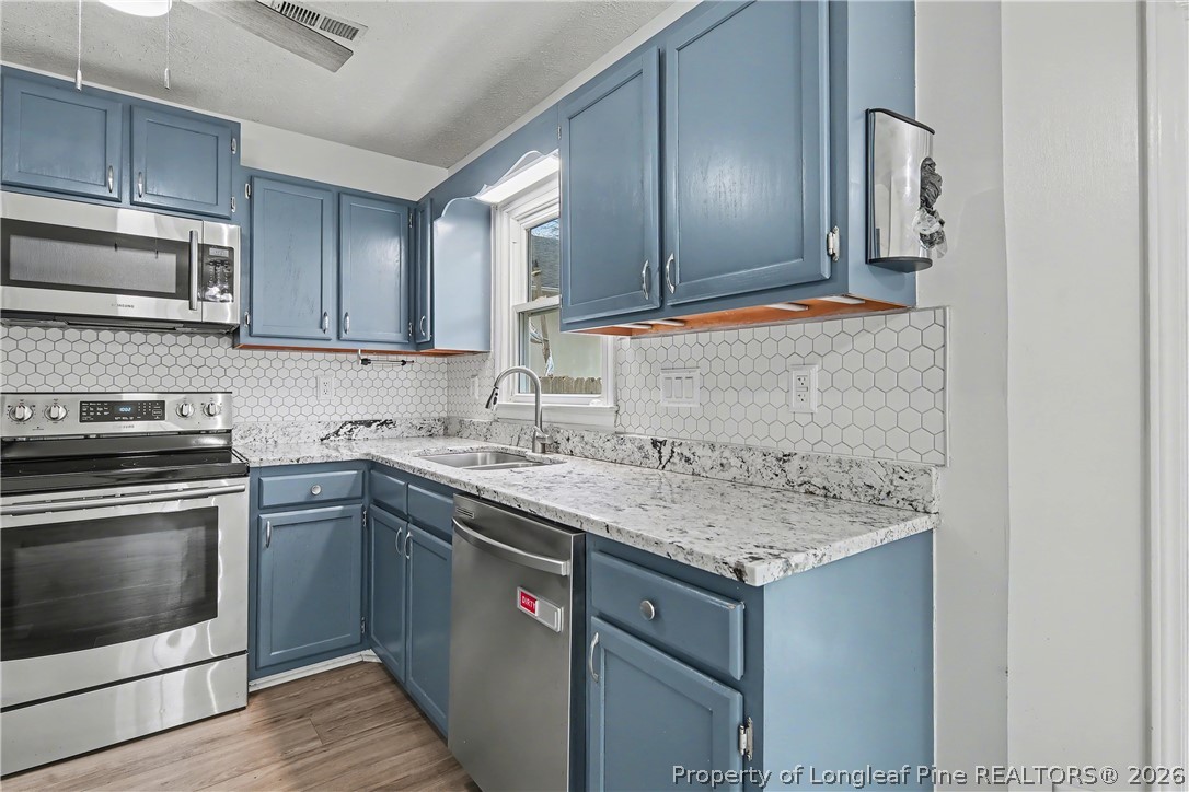 5073 Linton Hall Road Fayetteville, NC 28311 - Photo 13 of 32 a kitchen with a sink stove and microwave