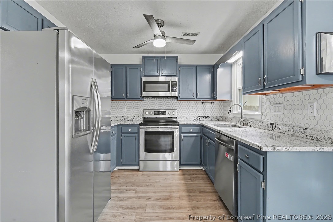 5073 Linton Hall Road Fayetteville, NC 28311 - Photo 14 of 32 a kitchen with stainless steel appliances granite countertop a stove a sink and a refrigerator