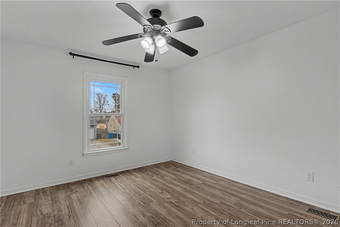 5073 Linton Hall Road Fayetteville, NC 28311 - Photo 16 of 32 an empty room with wooden floor ceiling fan and windows