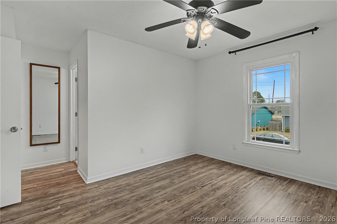 5073 Linton Hall Road Fayetteville, NC 28311 - Photo 17 of 32 an empty room with wooden floor chandelier and windows