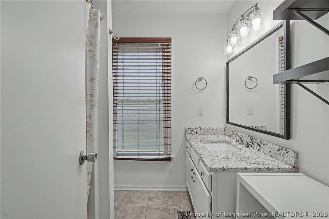 5073 Linton Hall Road Fayetteville, NC 28311 - Photo 18 of 32 a bathroom with a granite countertop sink and a mirror
