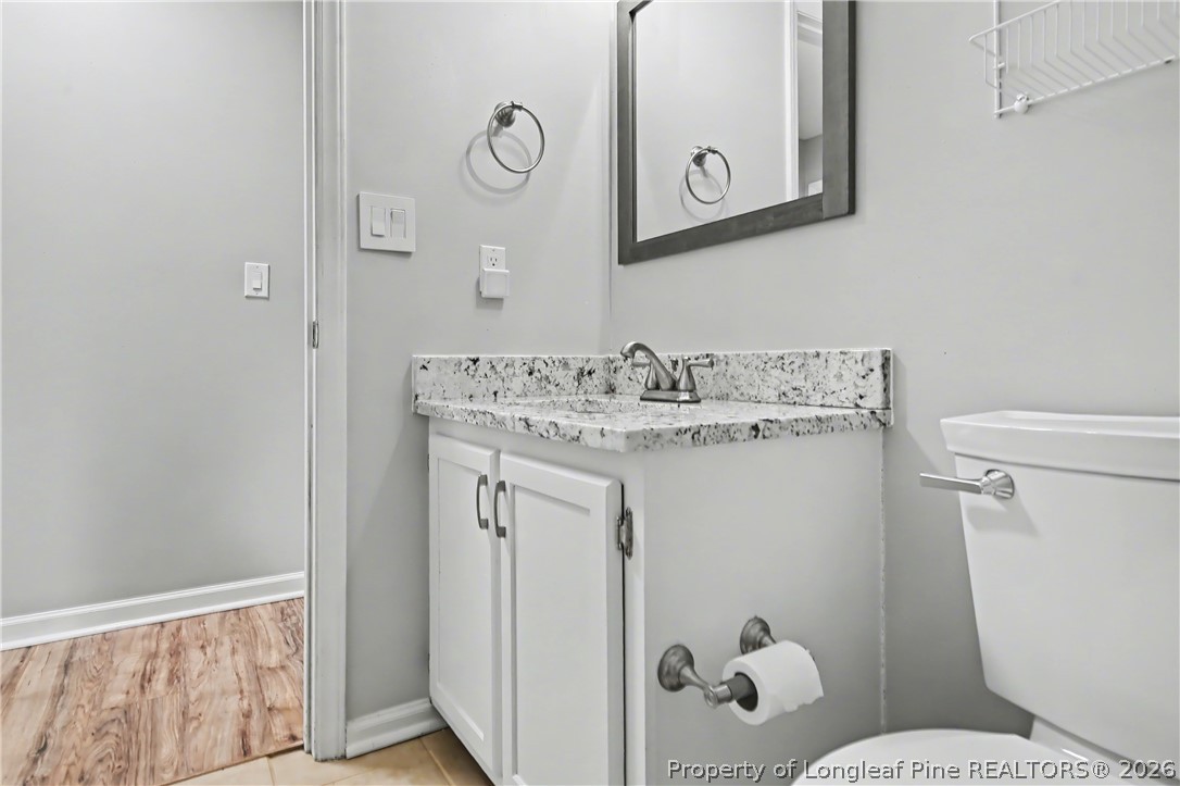 5073 Linton Hall Road Fayetteville, NC 28311 - Photo 25 of 32 a bathroom with a sink mirror vanity and toilet