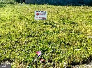 a sign that is sitting in front of a tree