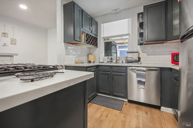 a kitchen with stainless steel appliances a sink stove and cabinets