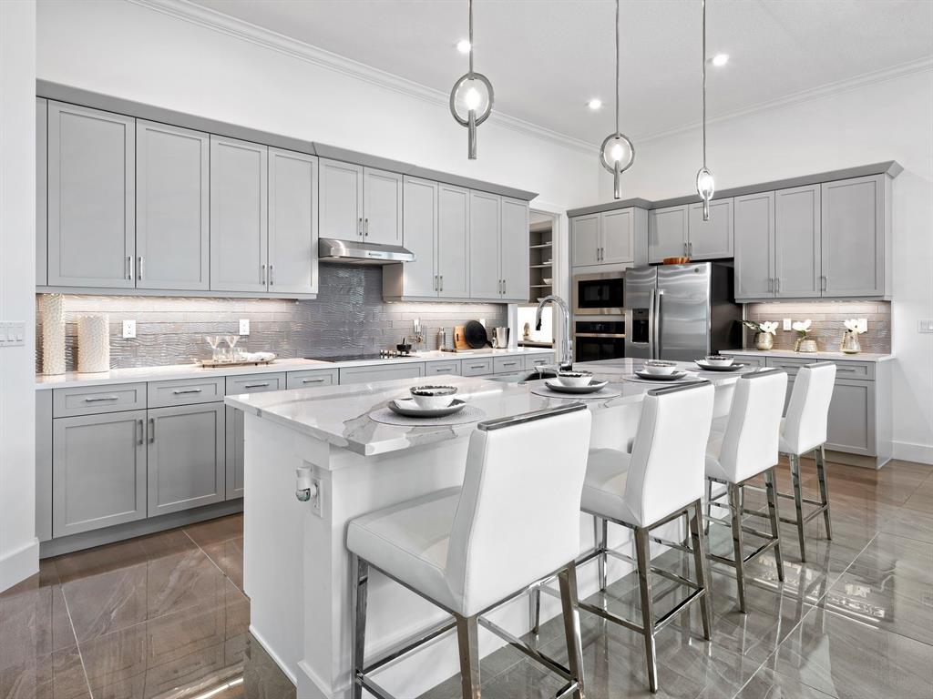 8146 Southwest Vanita Way Port St. Lucie, FL 34987 - Photo 15 of 53 a kitchen with kitchen island granite countertop a sink a center island stainless steel appliances and cabinets