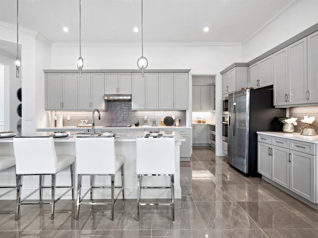 8146 Southwest Vanita Way Port St. Lucie, FL 34987 - Photo 16 of 53 a kitchen with stainless steel appliances kitchen island granite countertop a table chairs stove a refrigerator and a stove