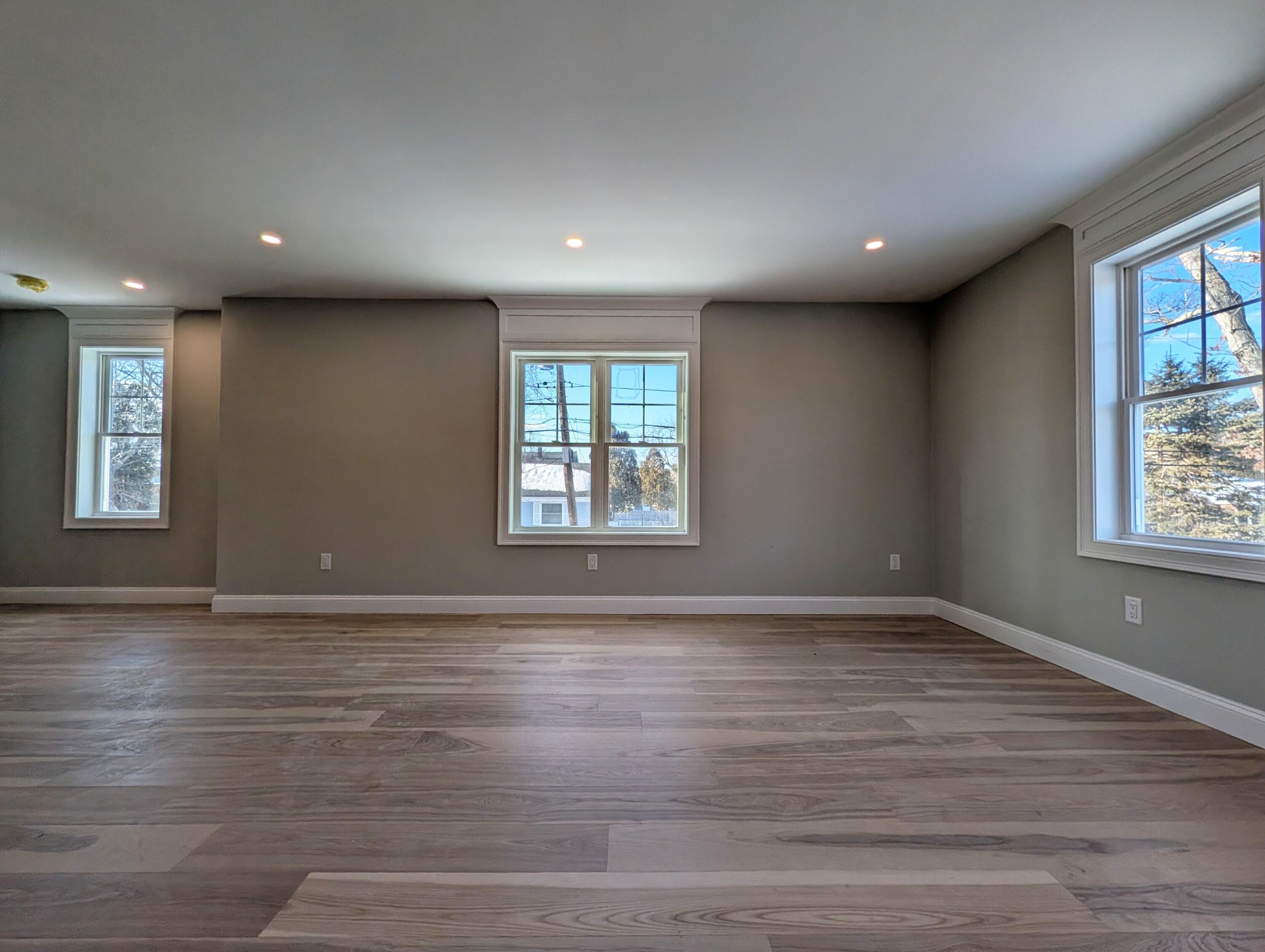 46 B Holt Road Bourne, MA 02532 - Photo 5 of 14 an empty room with wooden floor and windows