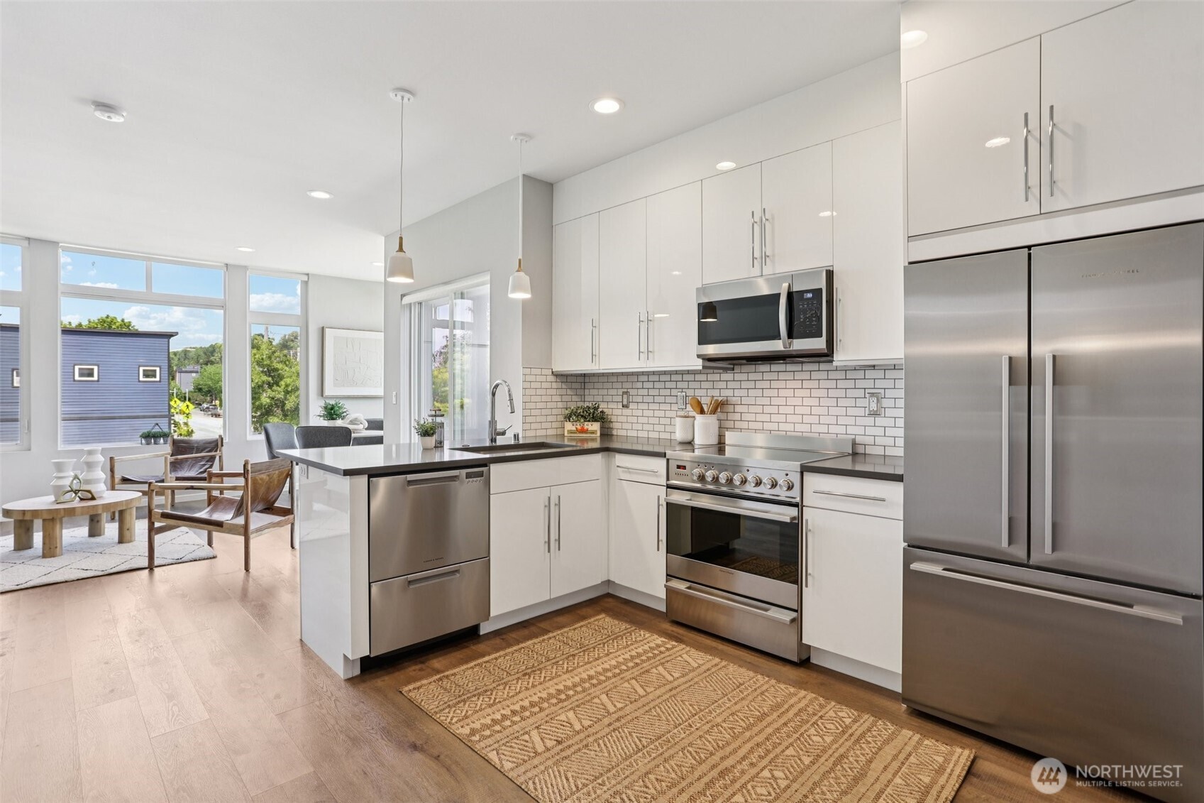 5017 Delridge Way Southwest, Unit A Seattle, WA 98106 - Photo 9 of 26 a kitchen with stainless steel appliances kitchen island granite countertop a stove a sink and a refrigerator