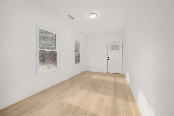 a view of an empty room with window and closet area