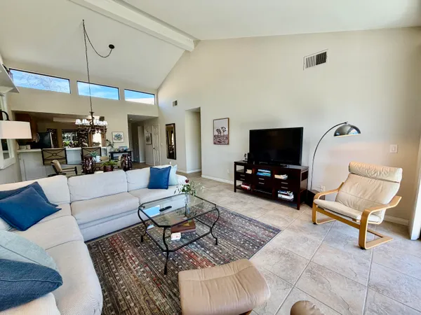 a kitchen with stainless steel appliances granite countertop a stove top oven a sink dishwasher a dining table and chairs with wooden floor