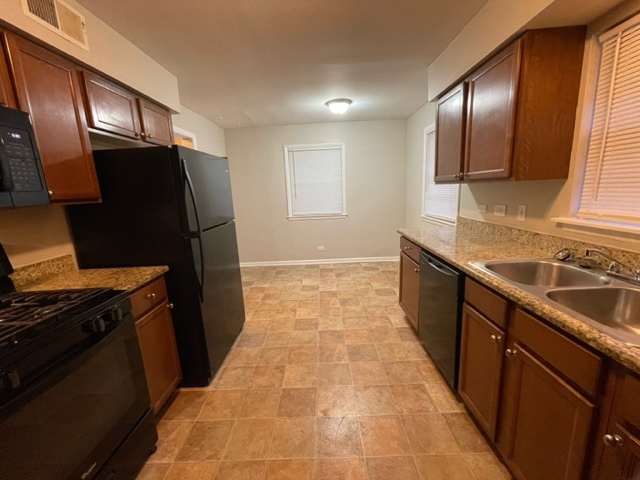 1424 Willow Road Homewood, IL 60430 - Photo 3 of 17 a kitchen with granite countertop stainless steel appliances a sink stove and refrigerator