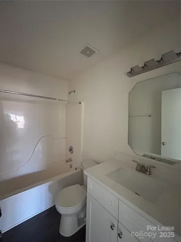 a bathroom with a granite countertop sink a toilet and a mirror