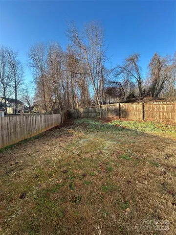 a view of a yard with wooden fence