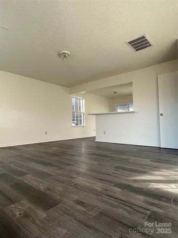 a view of empty room with window and wooden floor