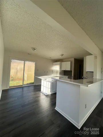 a kitchen with stainless steel appliances wooden floor and view living room
