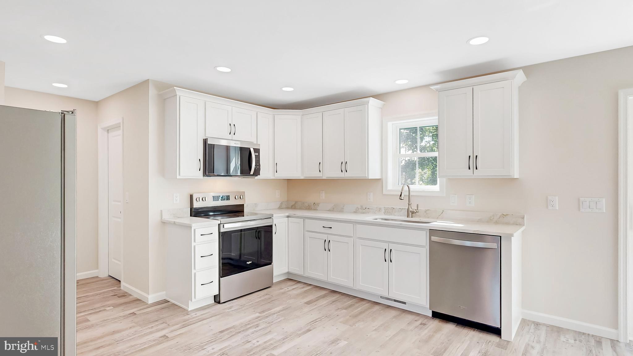 99 Cooper Street Kenton, DE 19938 - Photo 5 of 43 a kitchen with granite countertop white cabinets and white appliances