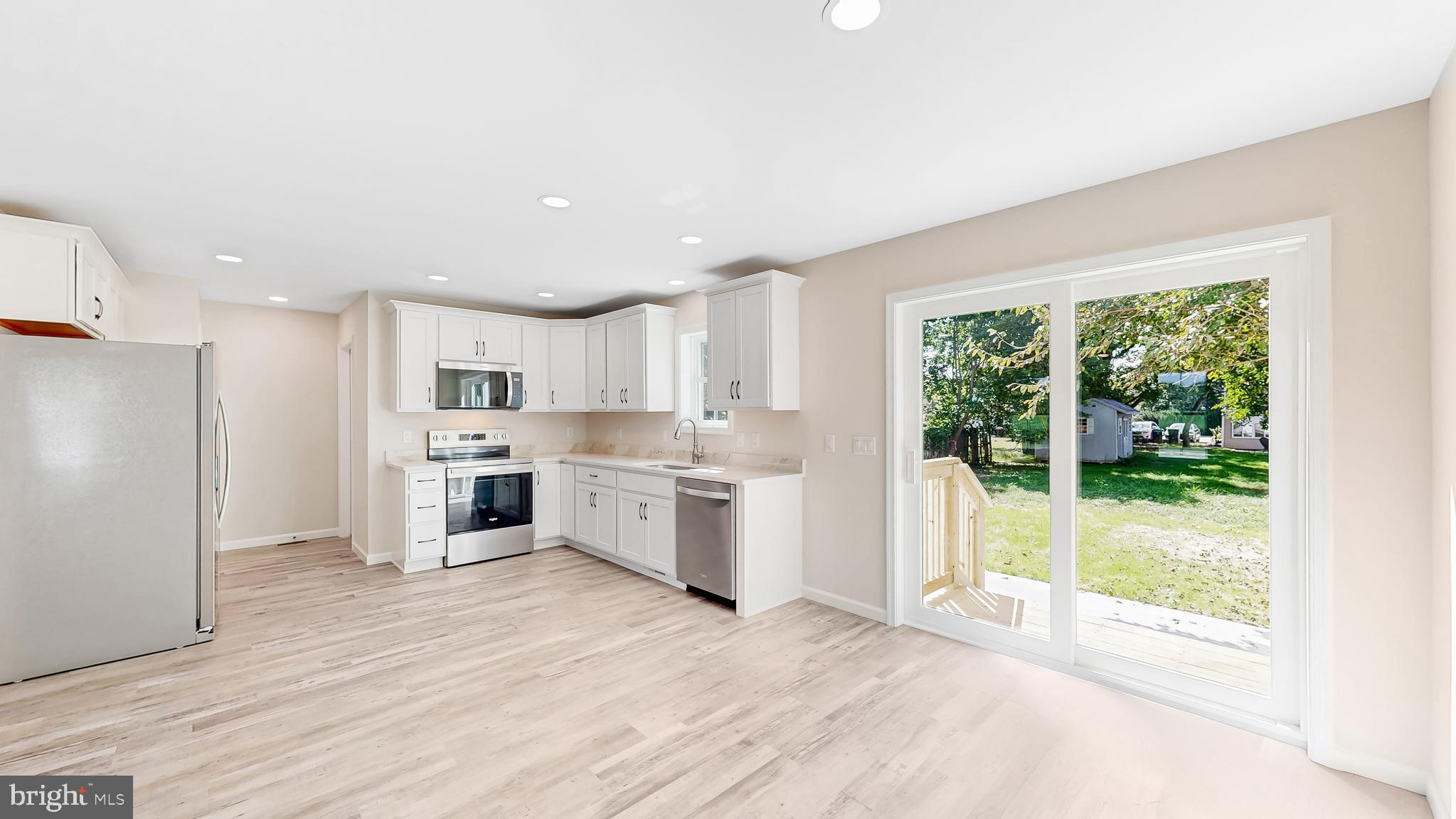 99 Cooper Street Kenton, DE 19938 - Photo 8 of 43 a view of a kitchen with a sink and dishwasher a refrigerator with wooden floor