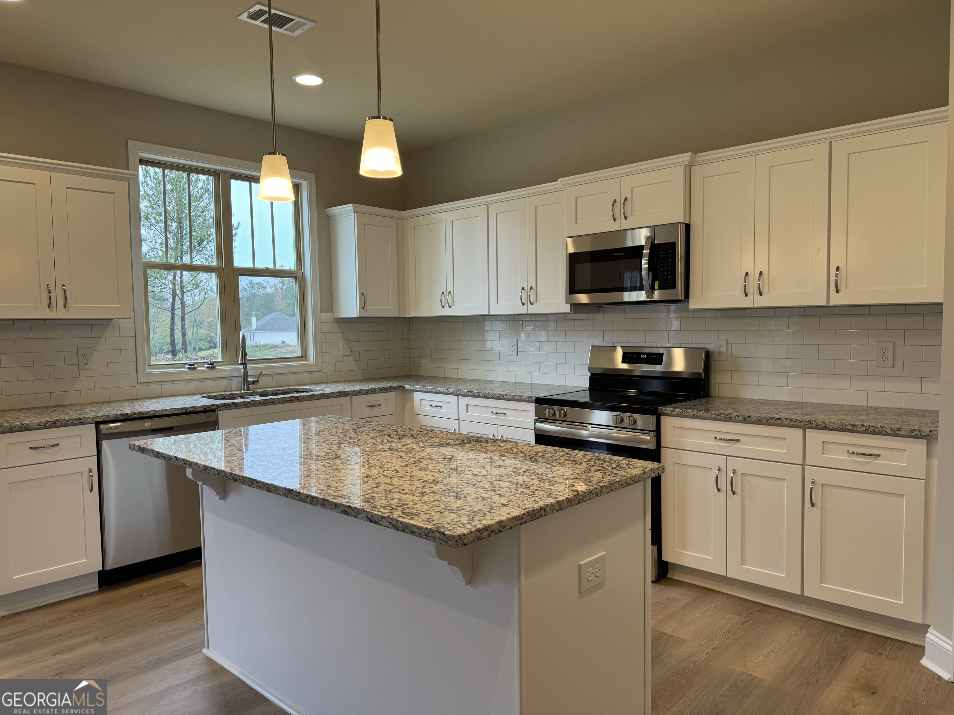 166 Country World Drive Macon, GA 31211 - Photo 29 of 33 a kitchen with stainless steel appliances granite countertop a sink a stove and a white cabinets