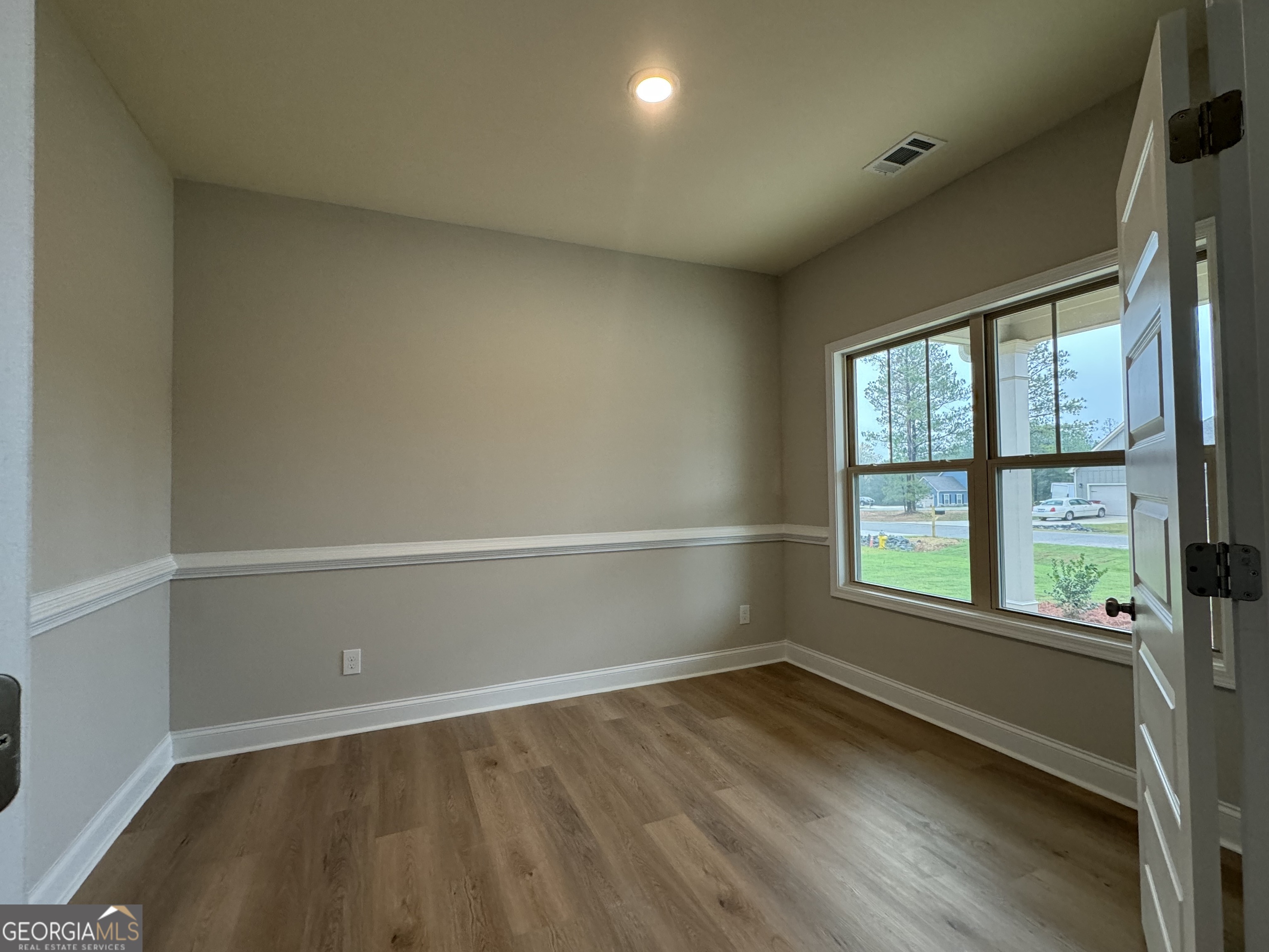 166 Country World Drive Macon, GA 31211 - Photo 3 of 33 an empty room with wooden floor and windows