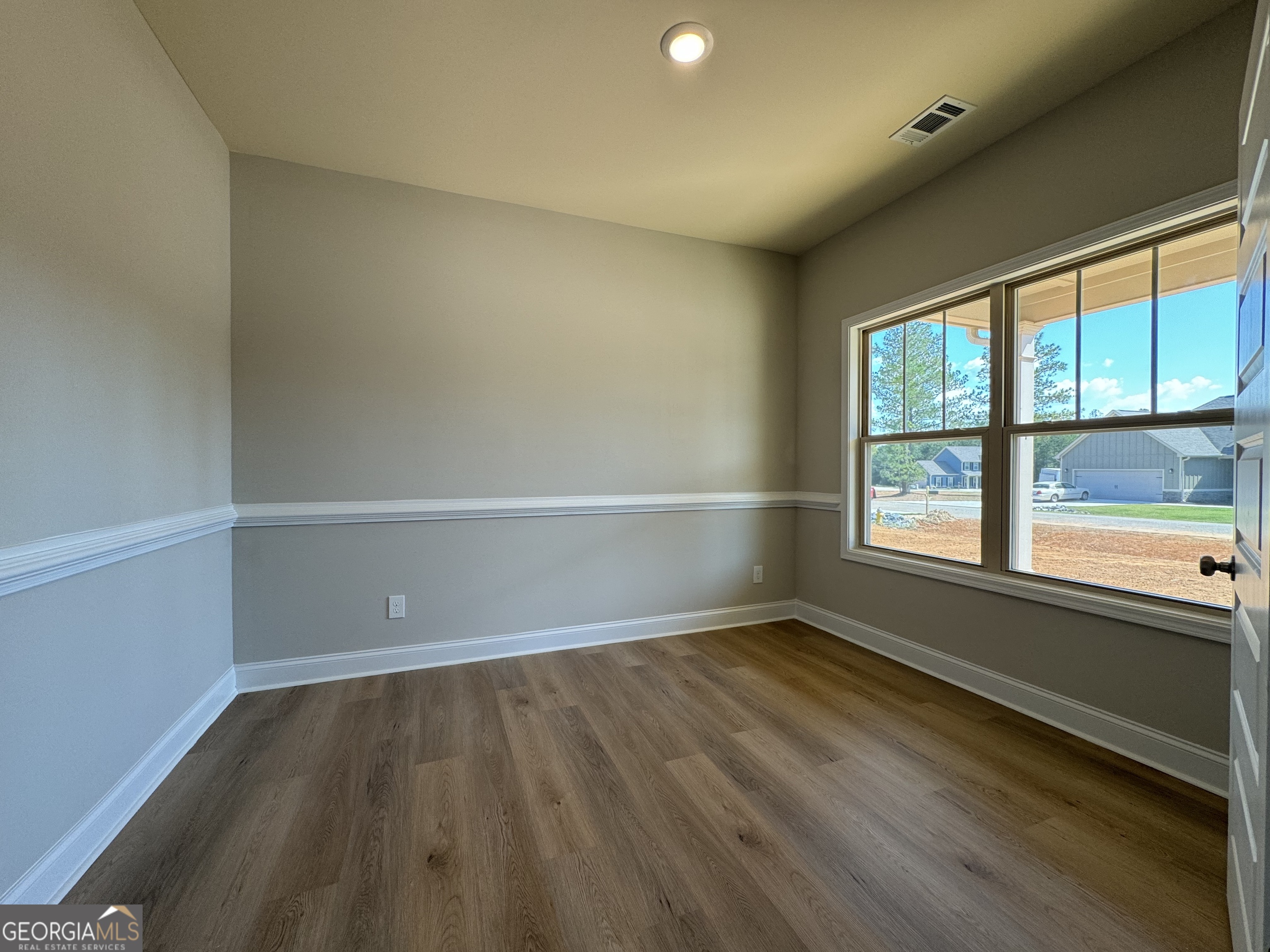 166 Country World Drive Macon, GA 31211 - Photo 7 of 33 an empty room with wooden floor and windows