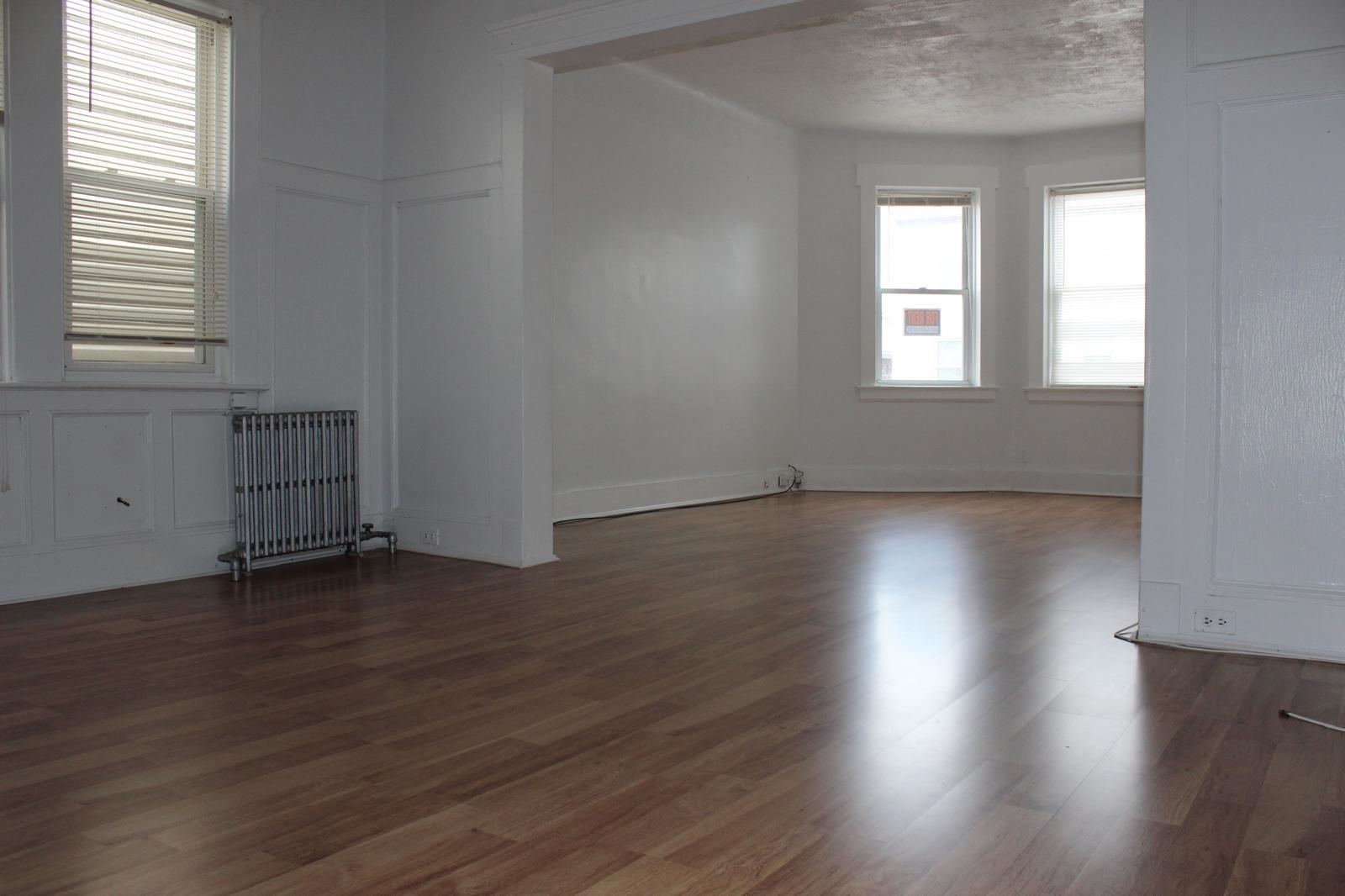 69 Poplar Street Jersey City, NJ 07307 - Photo 11 of 13 an empty room with wooden floor and windows