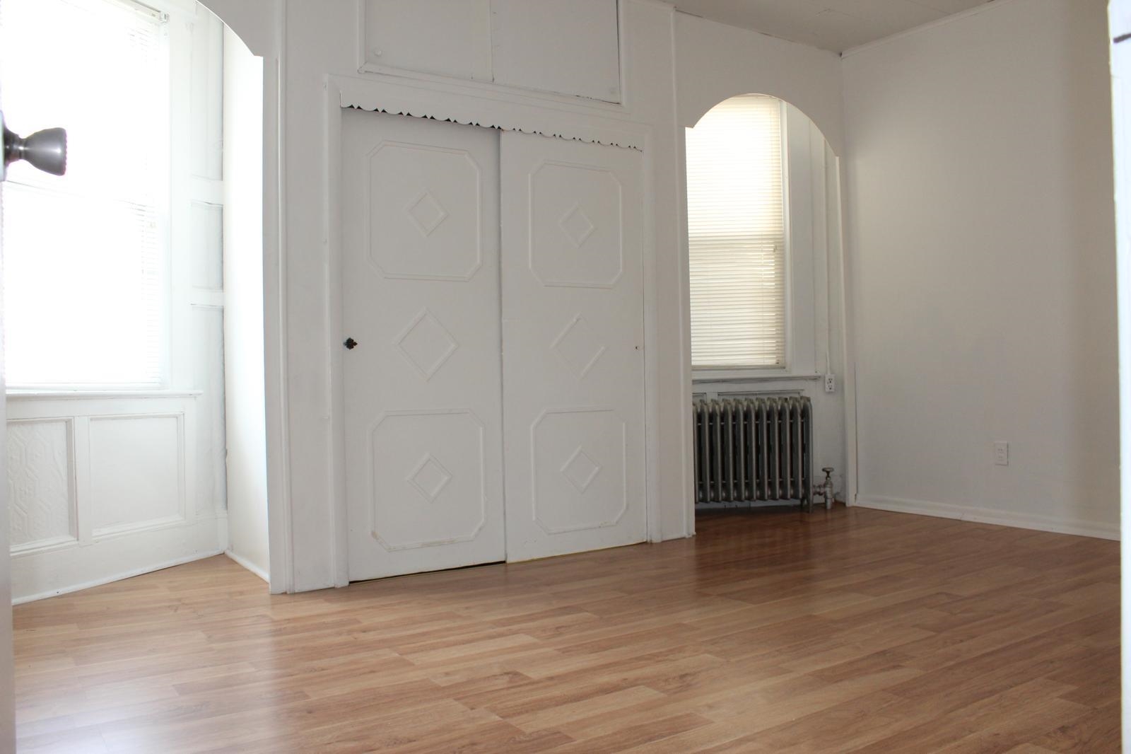 69 Poplar Street Jersey City, NJ 07307 - Photo 6 of 13 an empty room with wooden floor and windows