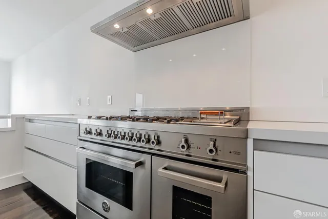 a kitchen with white cabinets and sink