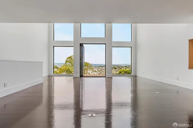 a large white kitchen with kitchen island a sink dishwasher and a refrigerator with wooden floor