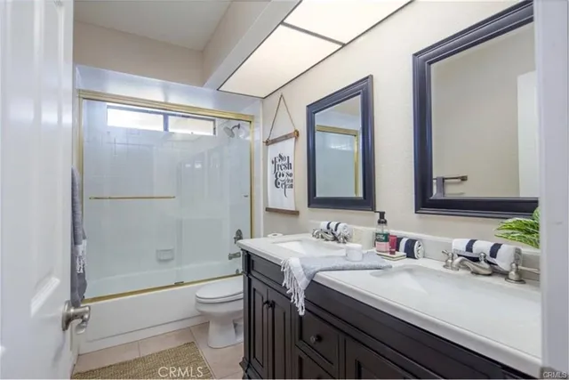 a bathroom with a granite countertop sink toilet mirror and shower