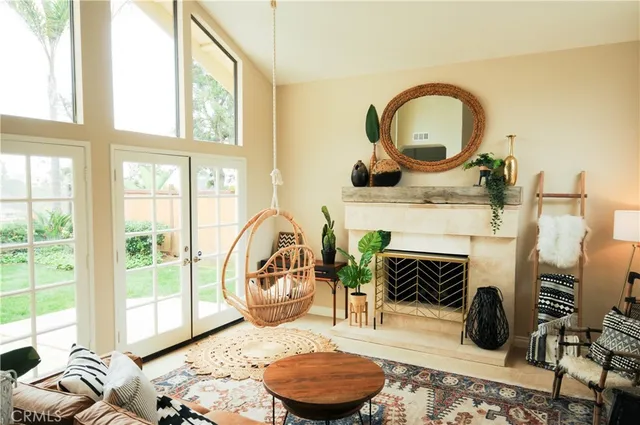 a living room with furniture a rug a fireplace and a large window