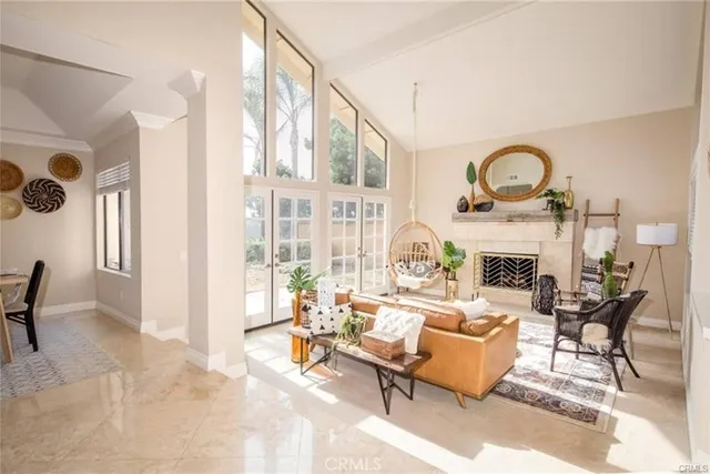 a living room with furniture a fireplace and a floor to ceiling window
