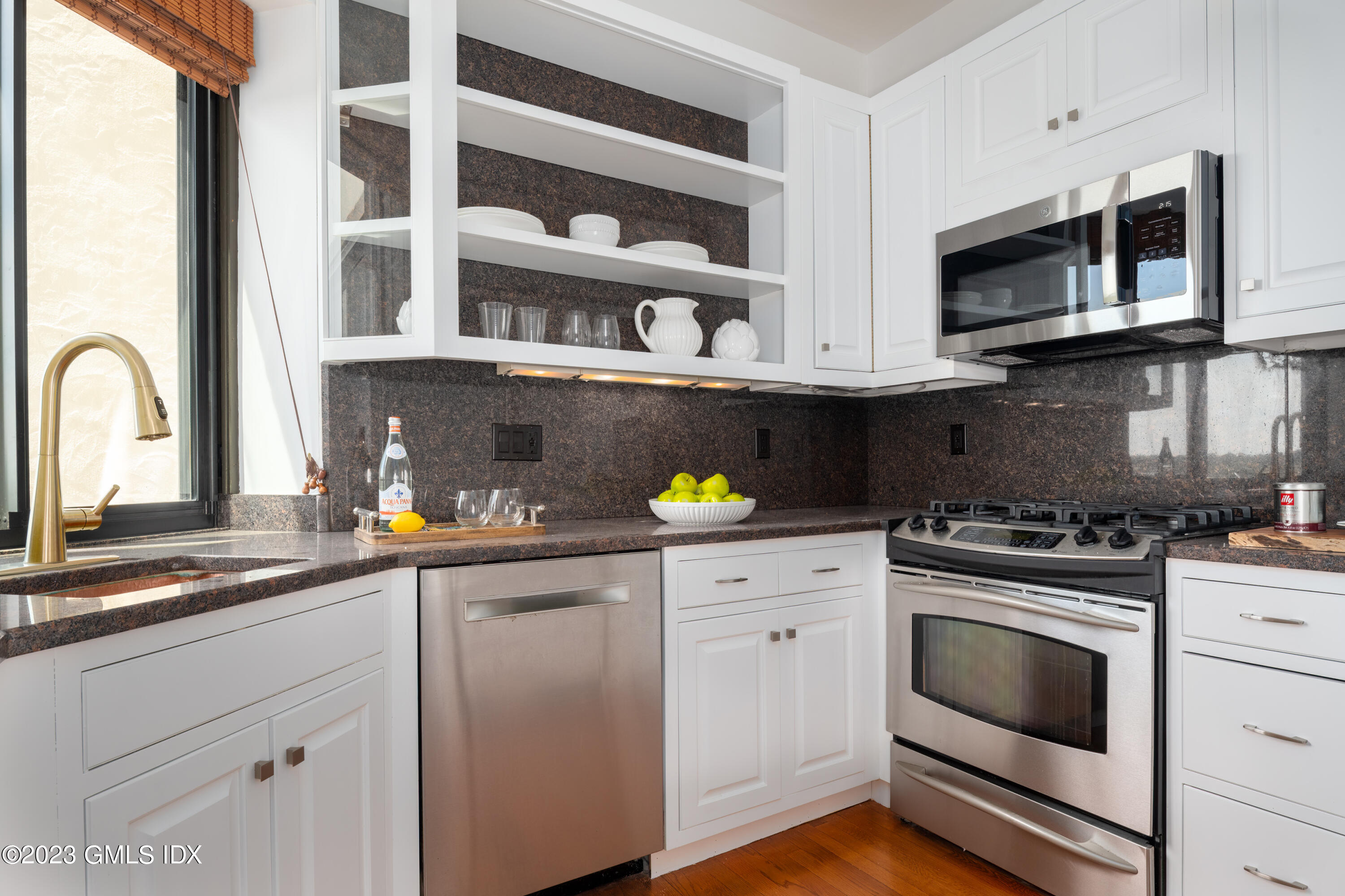 47 Lafayette Place, Unit 5F Greenwich, CT 06830 - Photo 8 of 18 a kitchen with stainless steel appliances granite countertop a stove a microwave and wooden cabinets