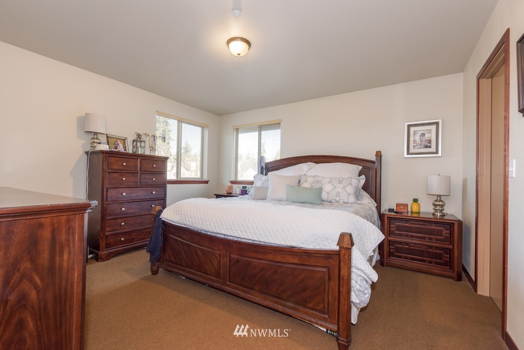 4821 Northeast Sunset Boulevard Renton, WA 98059 - Photo 11 of 12 a bedroom with a bed and wooden floor