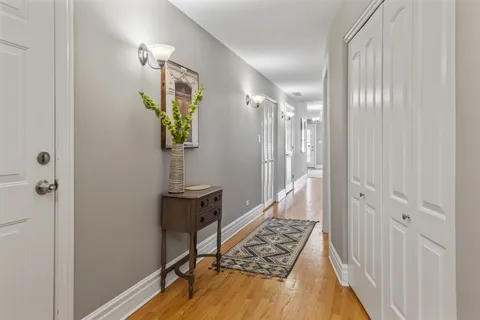 a view of a hallway with wooden floor and staircase