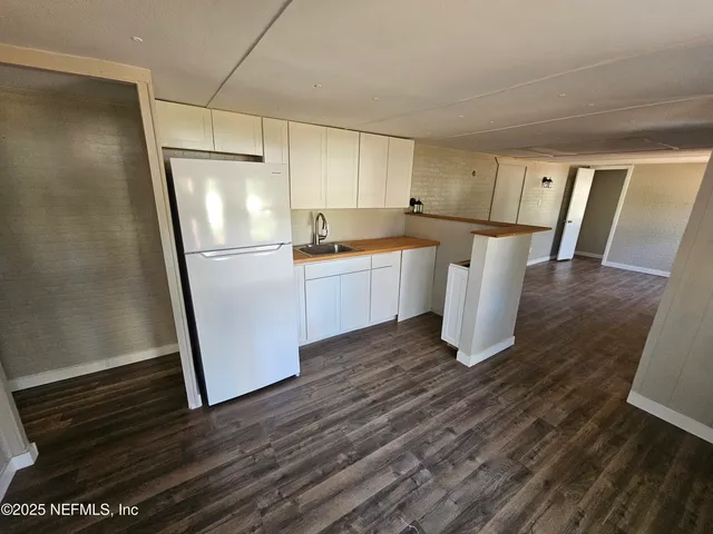 a kitchen with a refrigerator and a stove top oven