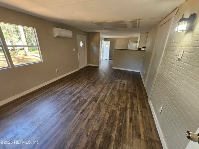 a view of a room with wooden floor electronic appliances and window