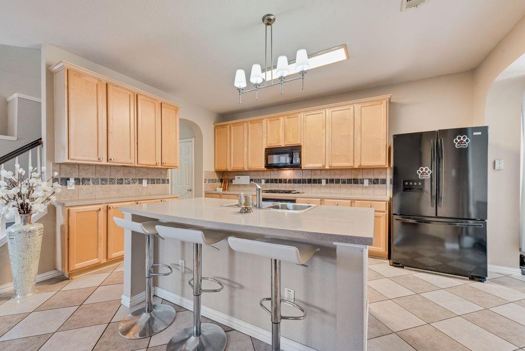 5404 Worley Drive The Colony, TX 75056 - Photo 12 of 30 a kitchen with kitchen island granite countertop a stove cabinets and refrigerator