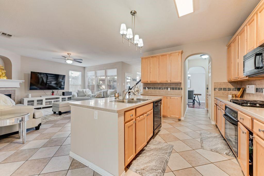 5404 Worley Drive The Colony, TX 75056 - Photo 29 of 30 a kitchen with stainless steel appliances granite countertop a stove top oven a sink dishwasher and a refrigerator with wooden floor
