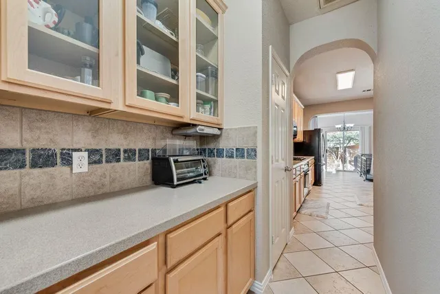 a kitchen with stainless steel appliances granite countertop a stove top oven a sink dishwasher and a refrigerator with wooden floor