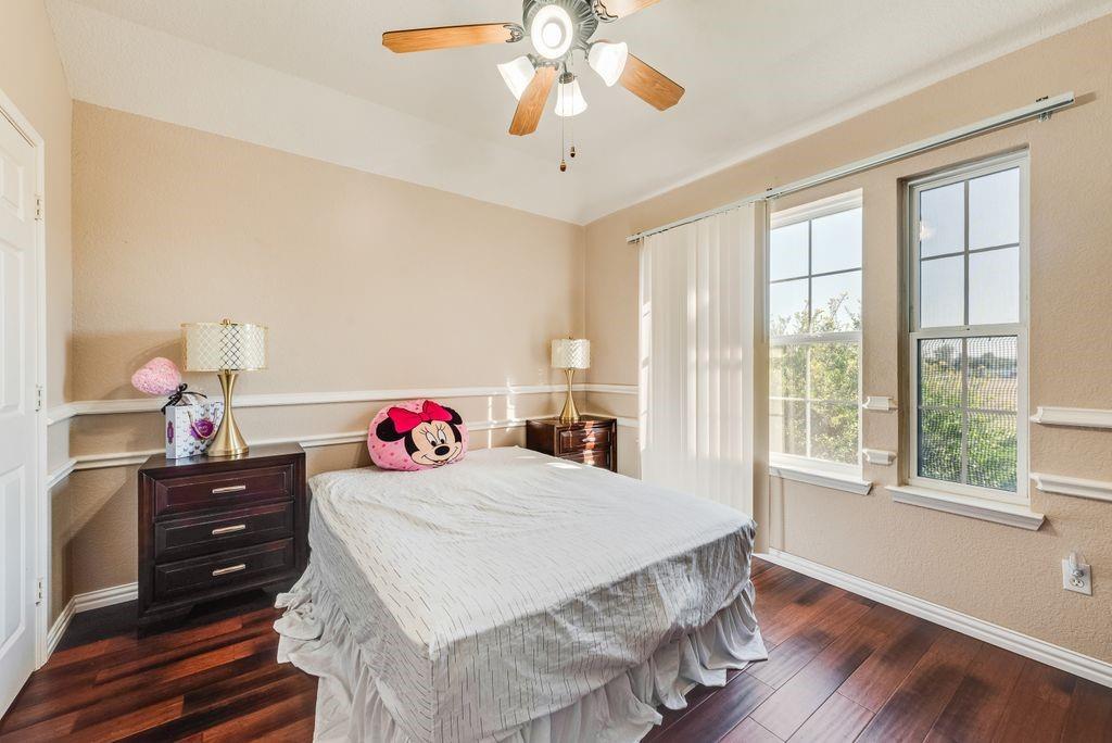 5404 Worley Drive The Colony, TX 75056 - Photo 17 of 30 a bedroom with a bed and a chandelier