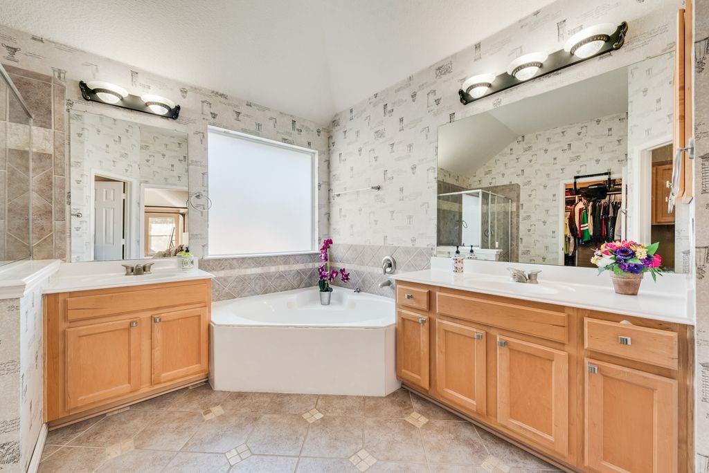 5404 Worley Drive The Colony, TX 75056 - Photo 24 of 30 a bathroom with a tub sink double vanity and mirror