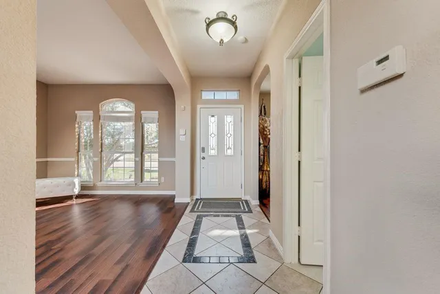 a view of a hallway with wooden floor and a chandelier