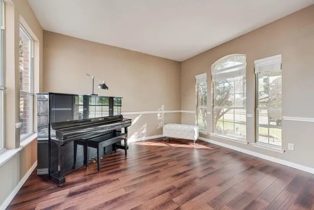 a living room with furniture a wooden floor and a large window