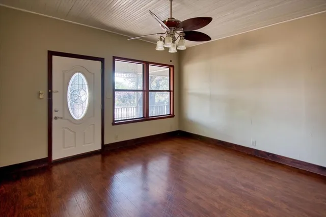 an empty room with wooden floor and a window