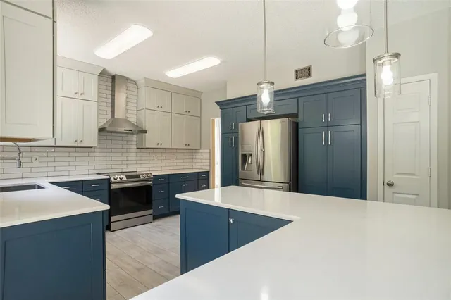 a large kitchen with cabinets and stainless steel appliances