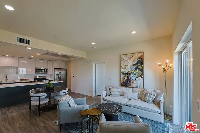 a living room with furniture kitchen view and a table